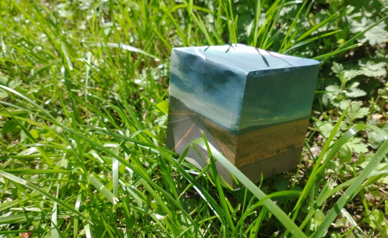 Papercraft cubemap resting in grass